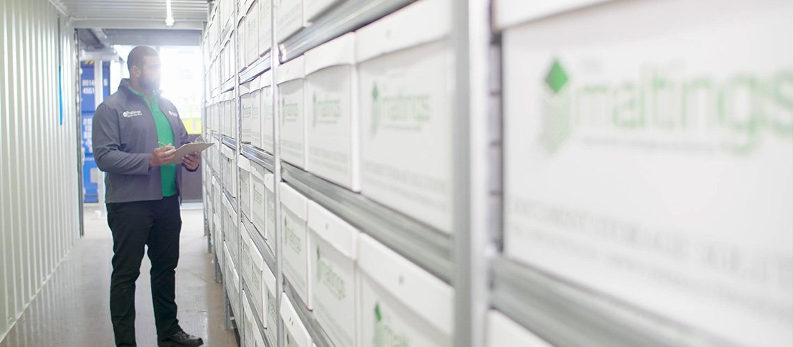 shelves of document storage boxes in the background