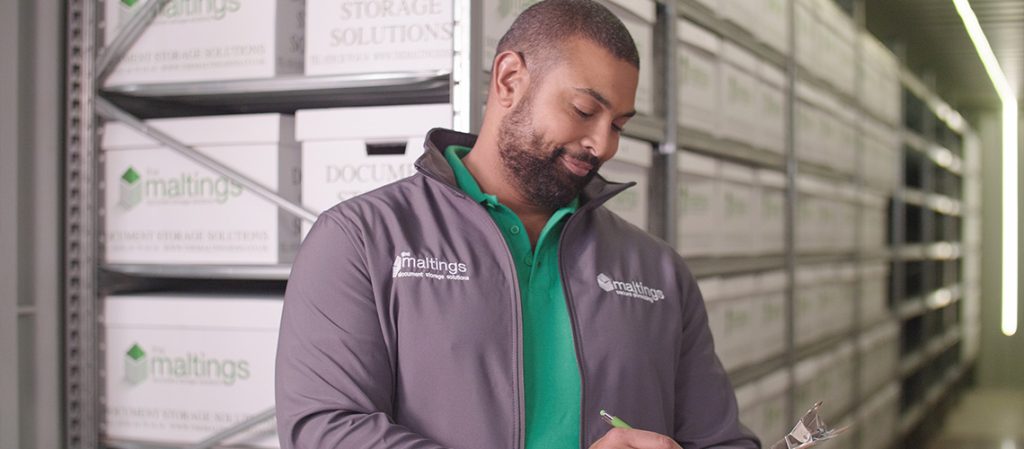 Employee checking records in secure document storage